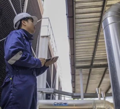 Técnico realiza manutenção preventiva em sistema de exaustão industrial para garantir segurança e eficiência operacional.