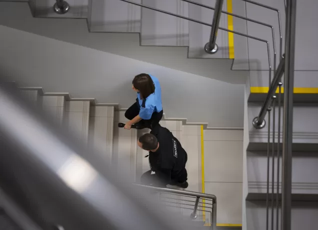 Profissionais realizando manutenção preventiva de sistema de pressurização de escadas em edifício.