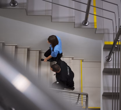 Escada de emergência pressurizada sendo utilizada por pessoas durante evacuação segura, exemplo de pressurização de escadas obrigatória em edifícios.