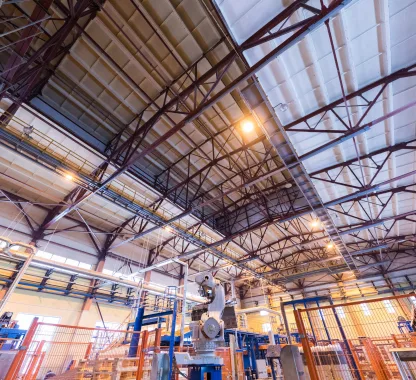 Galpão industrial com estrutura metálica e máquinas evidenciando necessidade de sistema de ventilação para conforto térmico